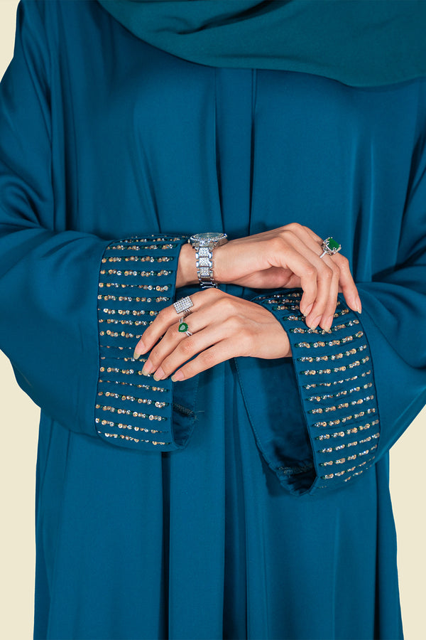 Close-up of Zareen Abaya’s pleated sleeve with golden and zinc stone embellishments